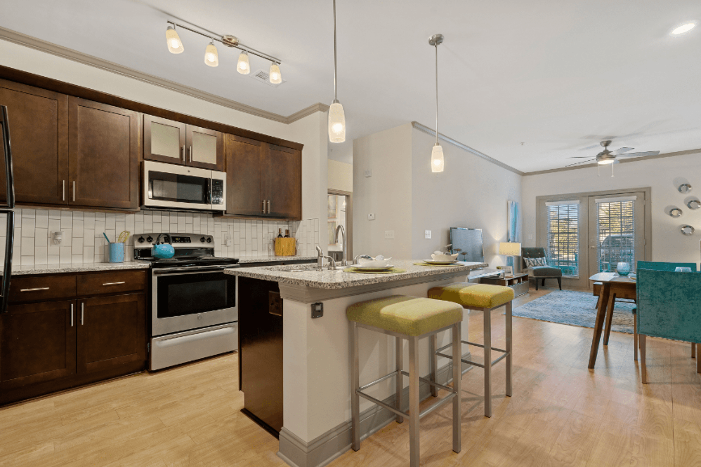 an open kitchen and living room with a bar and stools