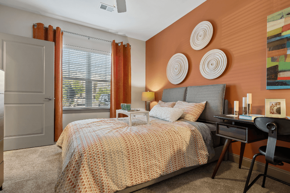 an orange bedroom with a bed and a desk with a chair