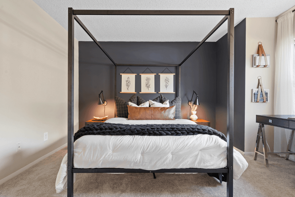 a bedroom with a large bed and a black canopy bed
