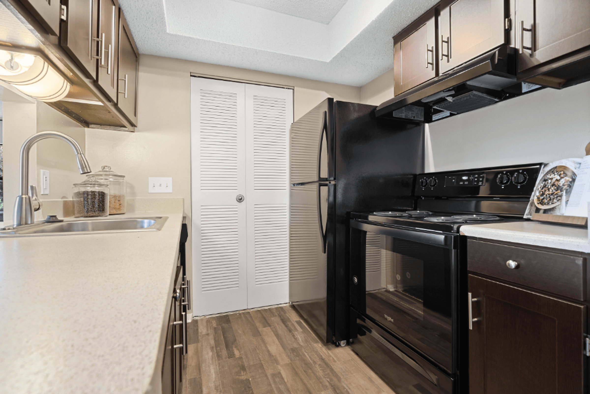 a kitchen with black appliances and a sink and a refrigerator