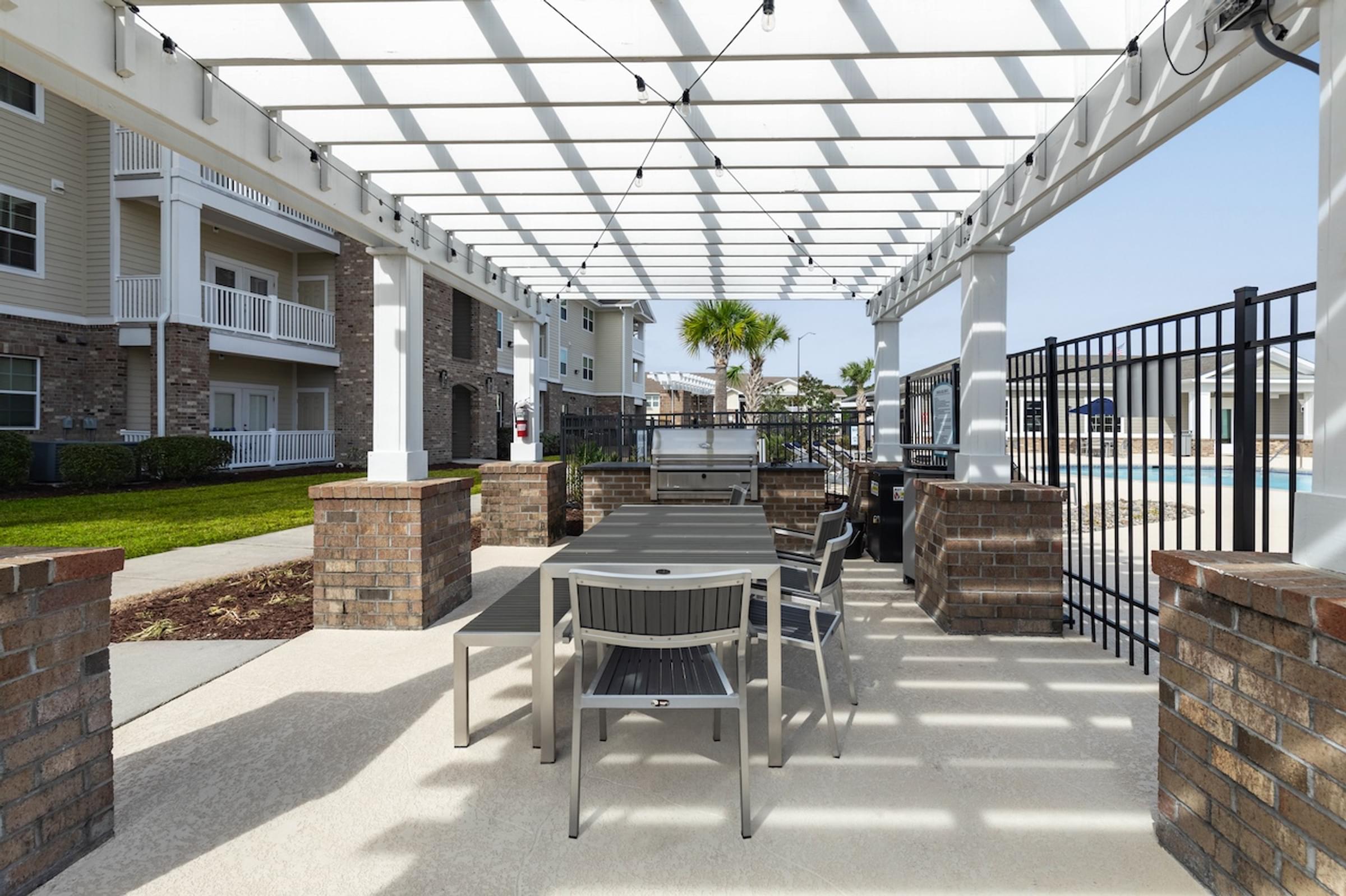 an outdoor patio area with tables and chairs under a white canopy