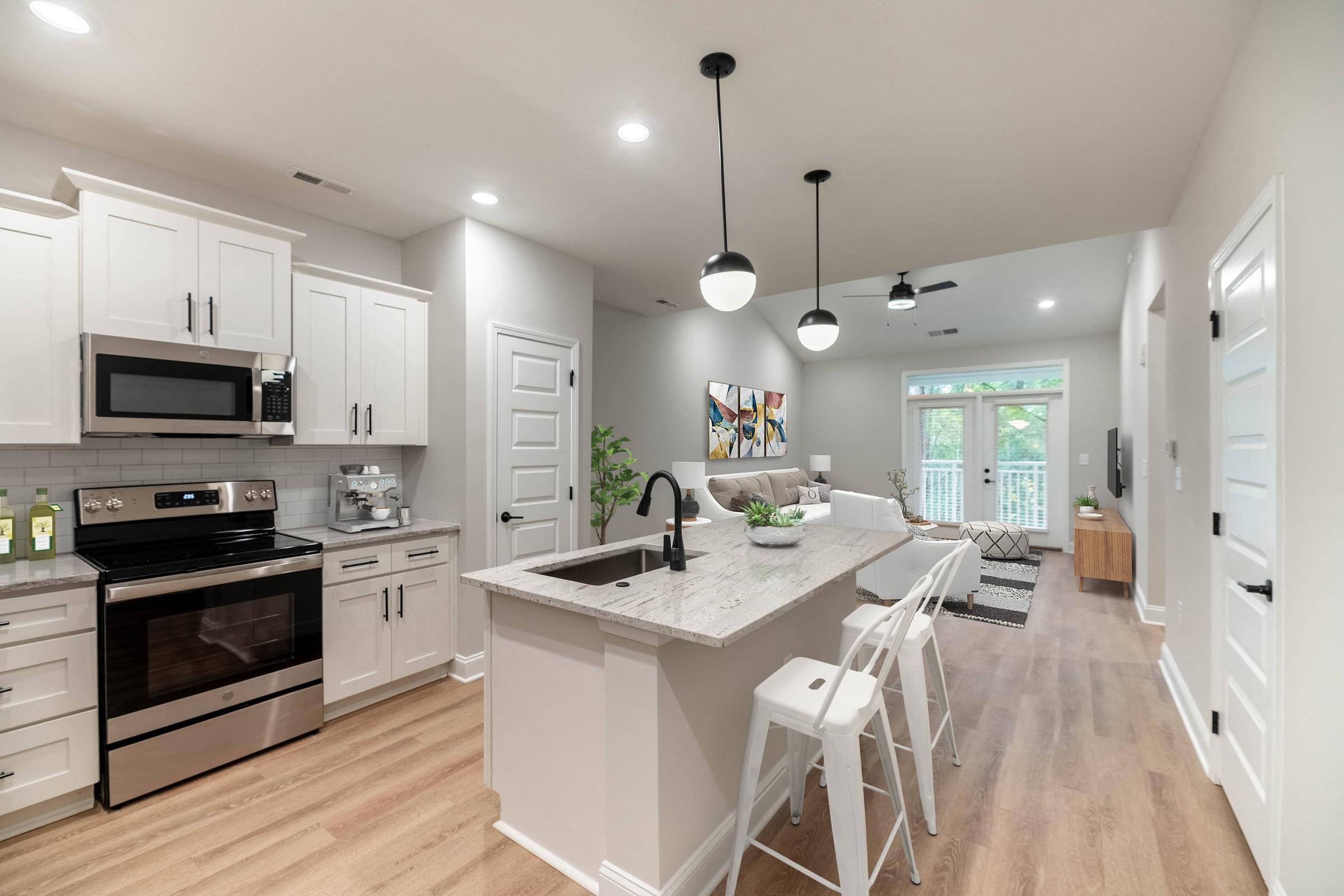 A modern kitchen with white cabinets and a large island.