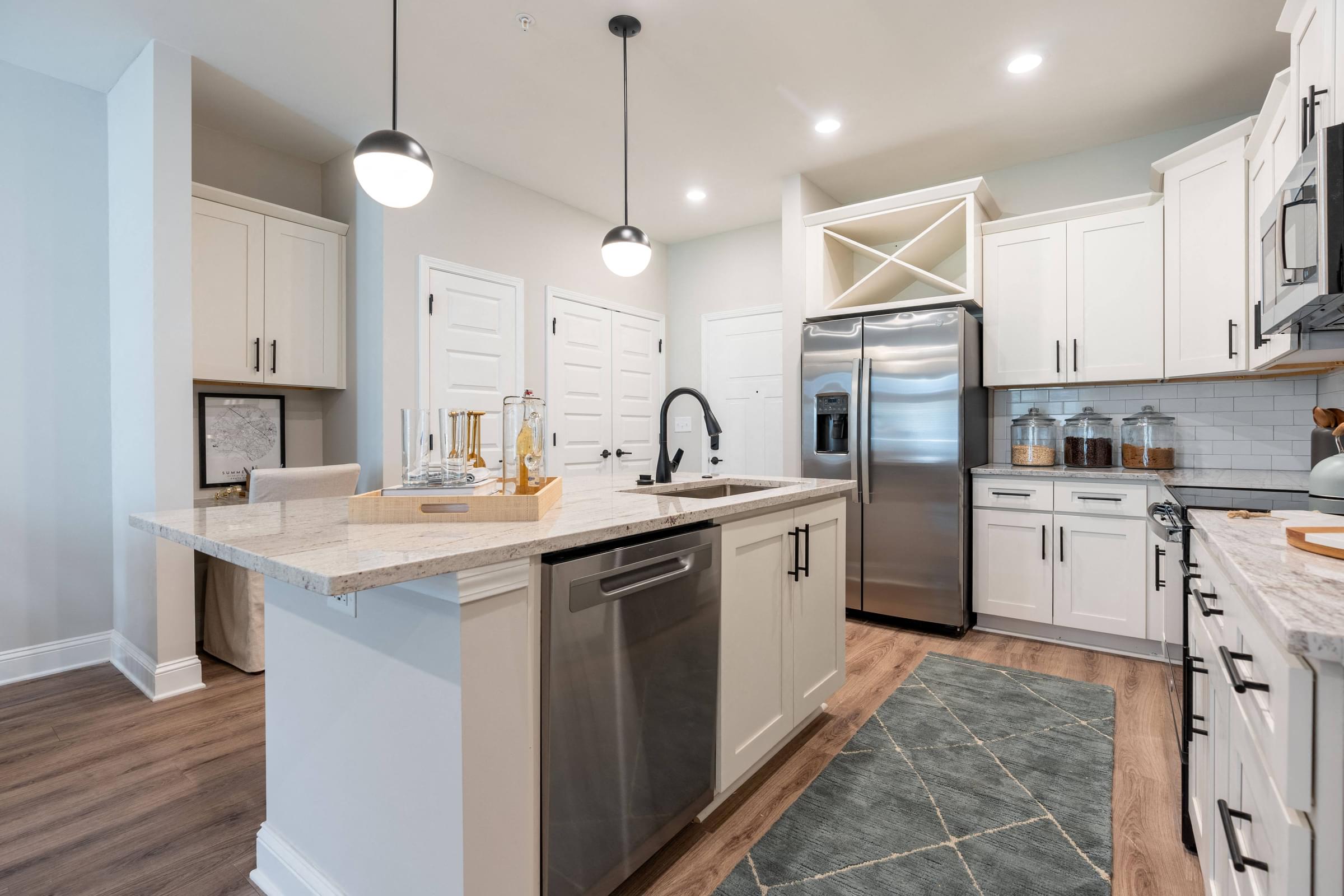 a large kitchen with white cabinets and stainless steel appliances