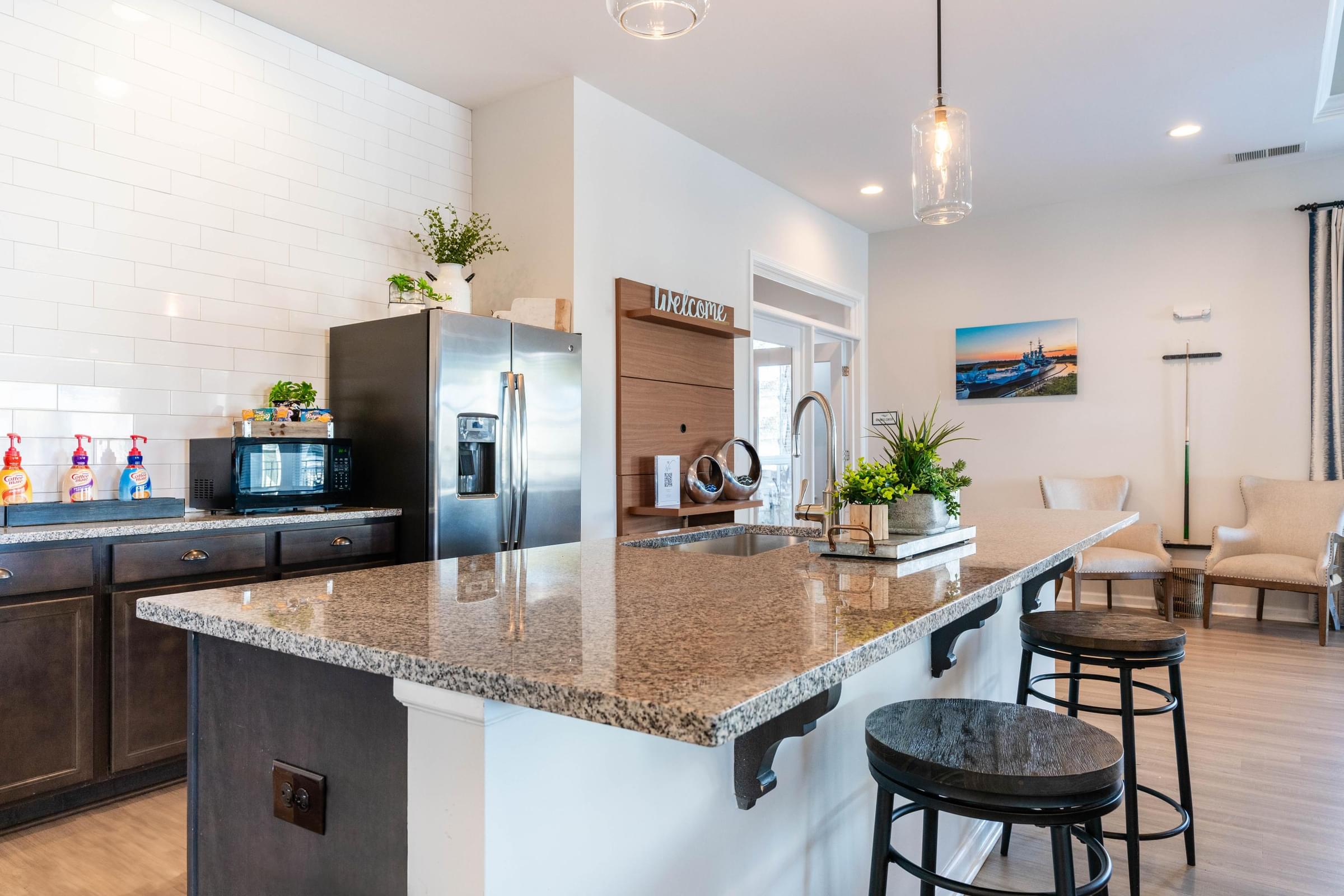 a kitchen with a granite counter top and a stainless steel refrigerator
