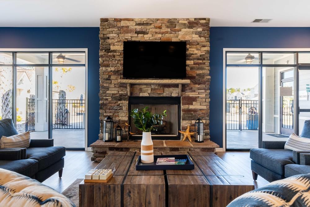 a living room with blue walls and a stone fireplace