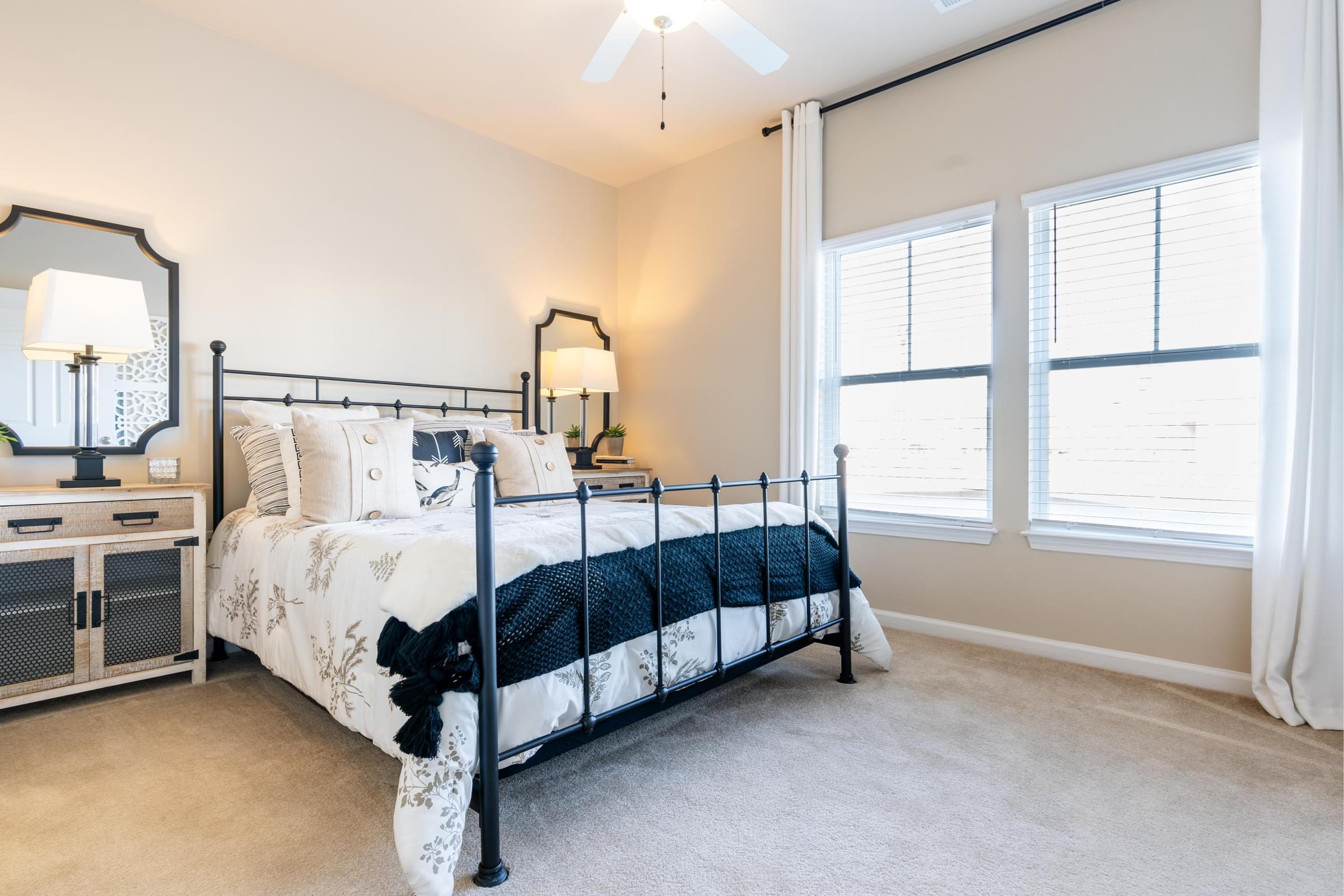 a bedroom with a bed and two windows