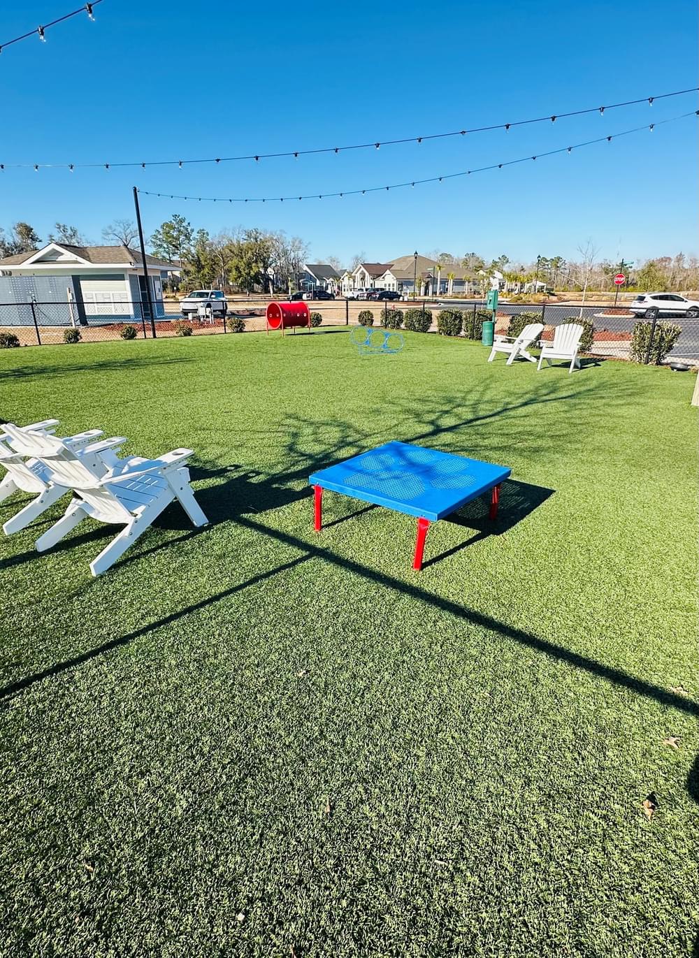 a blue ping pong table on the grass next to chairs