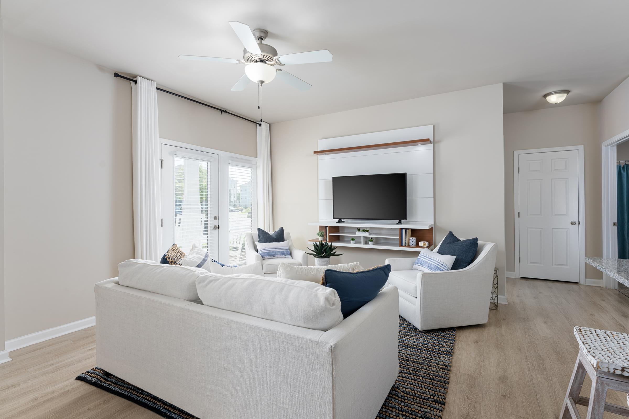 A living room with a white couch and a television.