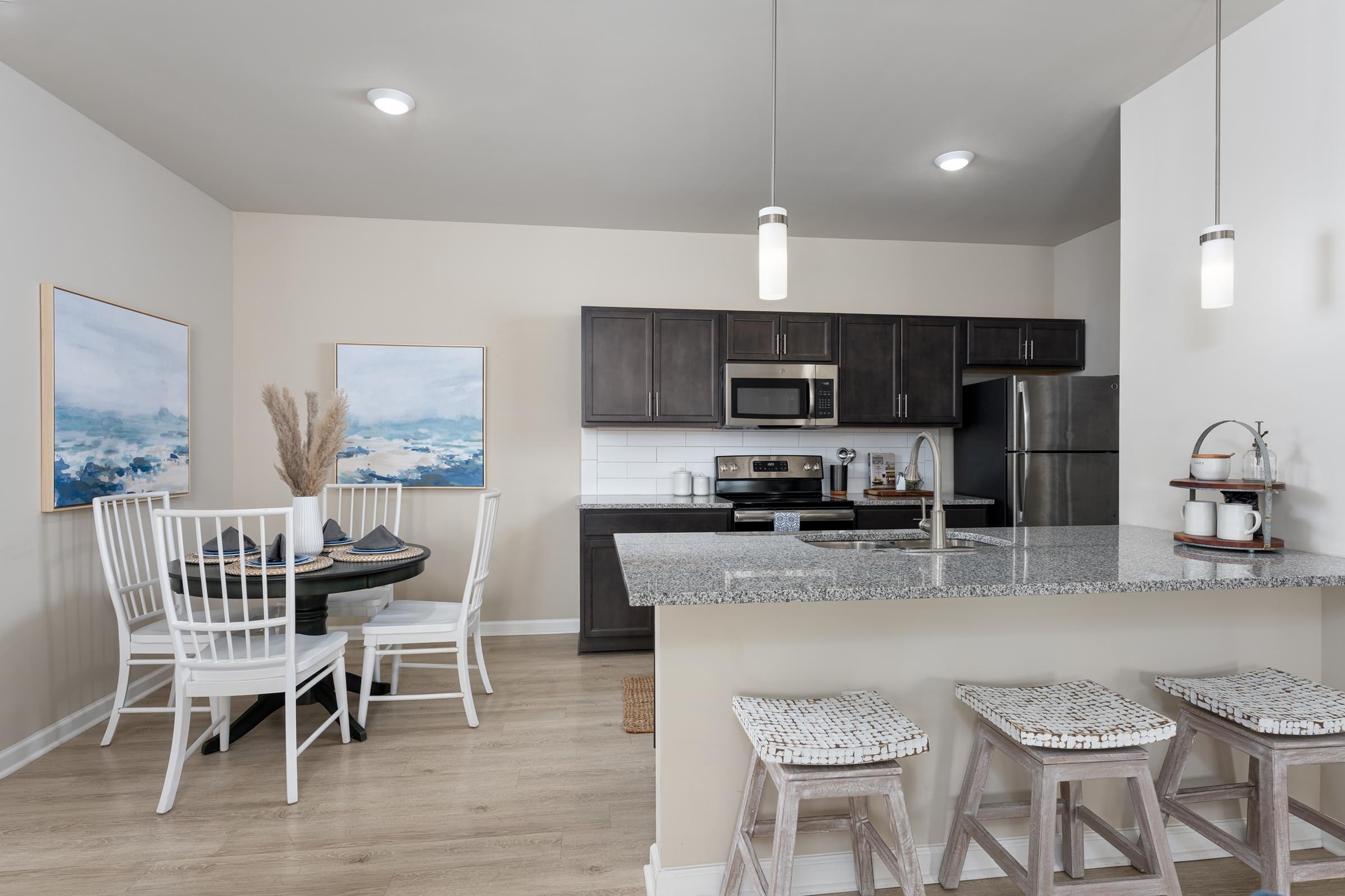 A kitchen with a dining table and chairs.