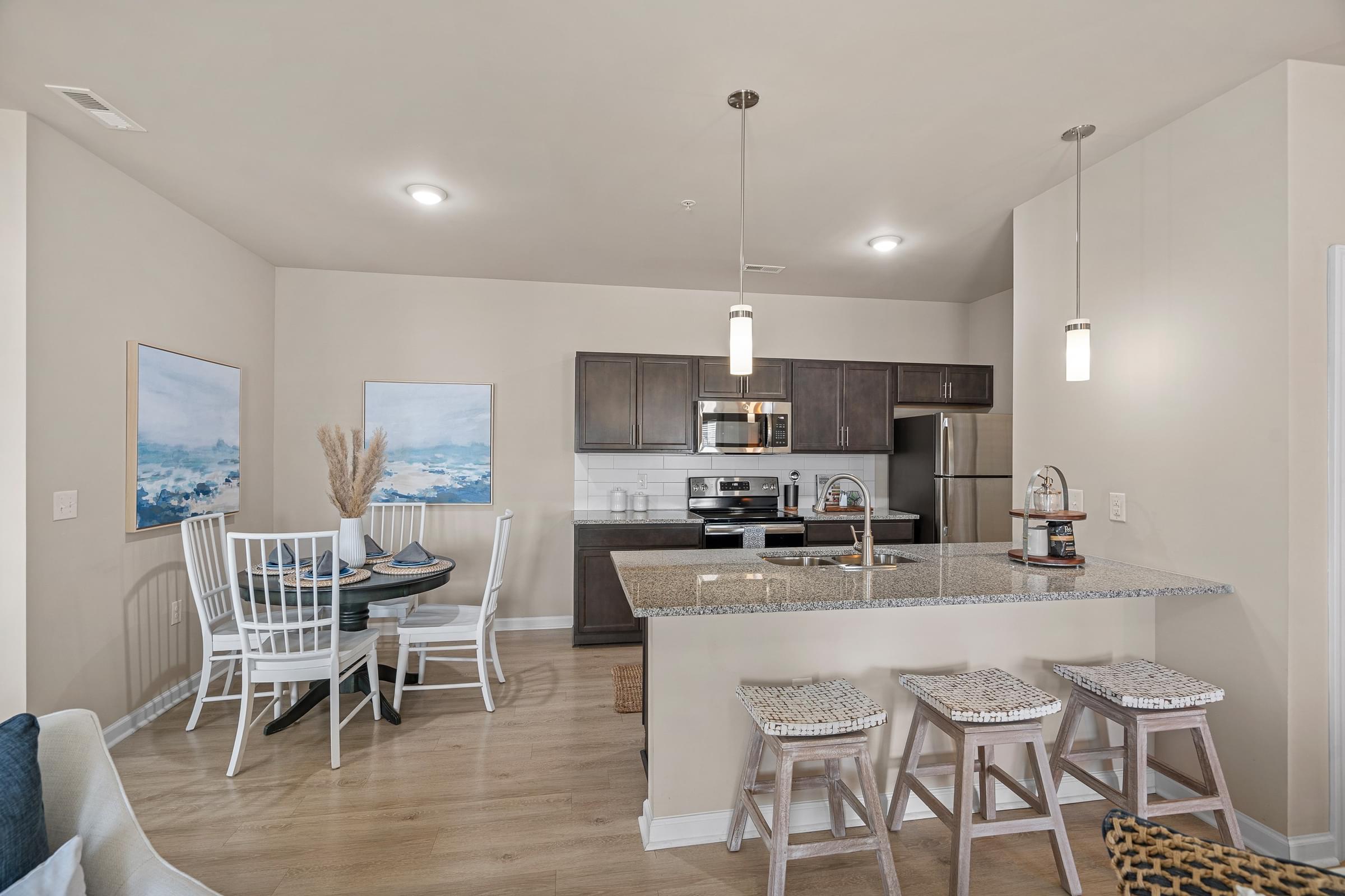 A modern kitchen with a dining table and chairs.