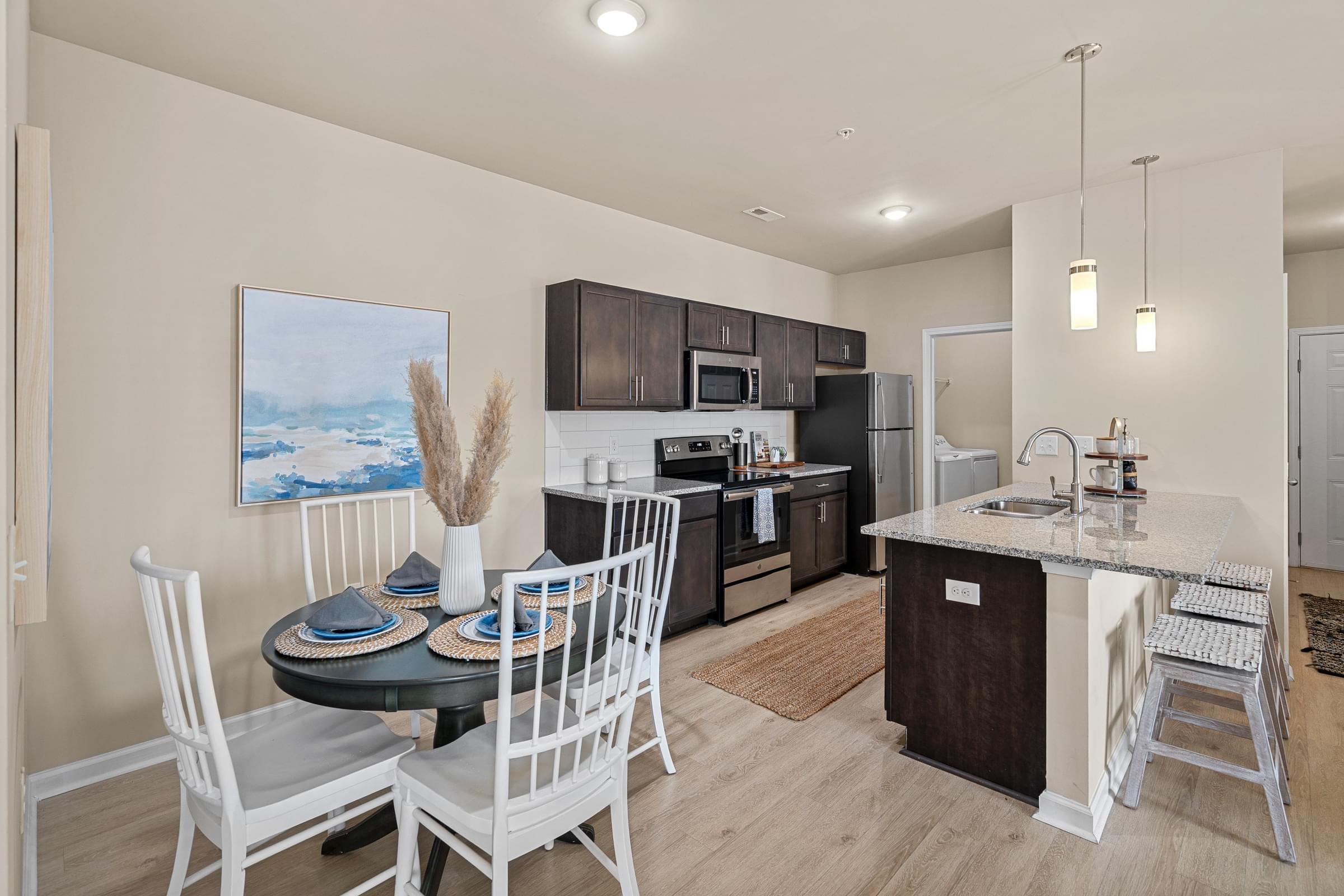 A kitchen with a table and chairs and a painting on the wall.