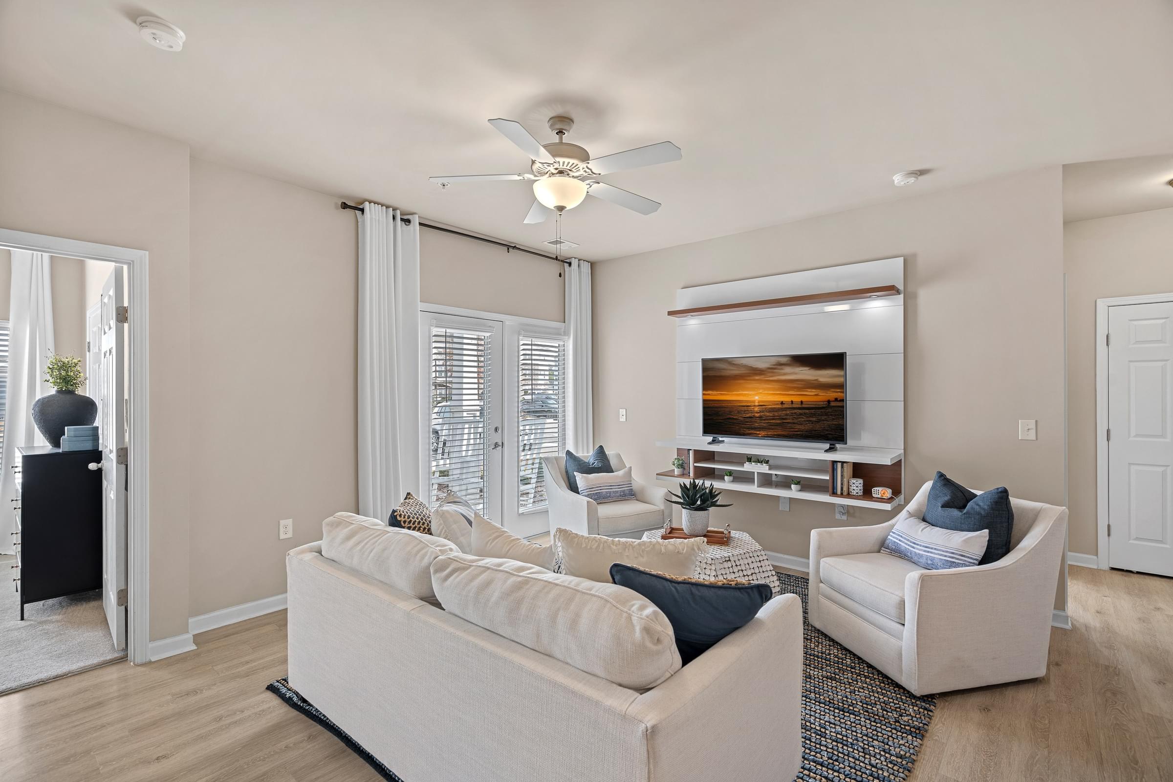A living room with a white couch and a ceiling fan.