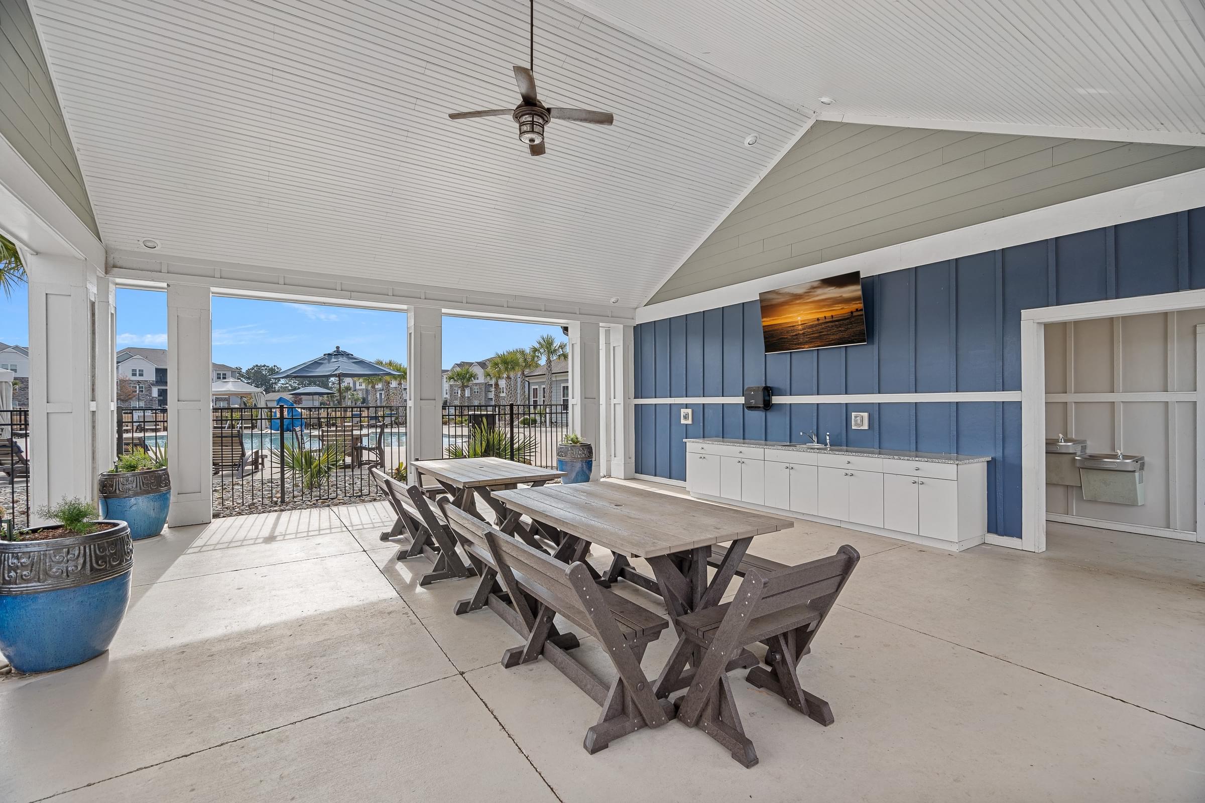 A patio with a table and chairs and a ceiling fan.