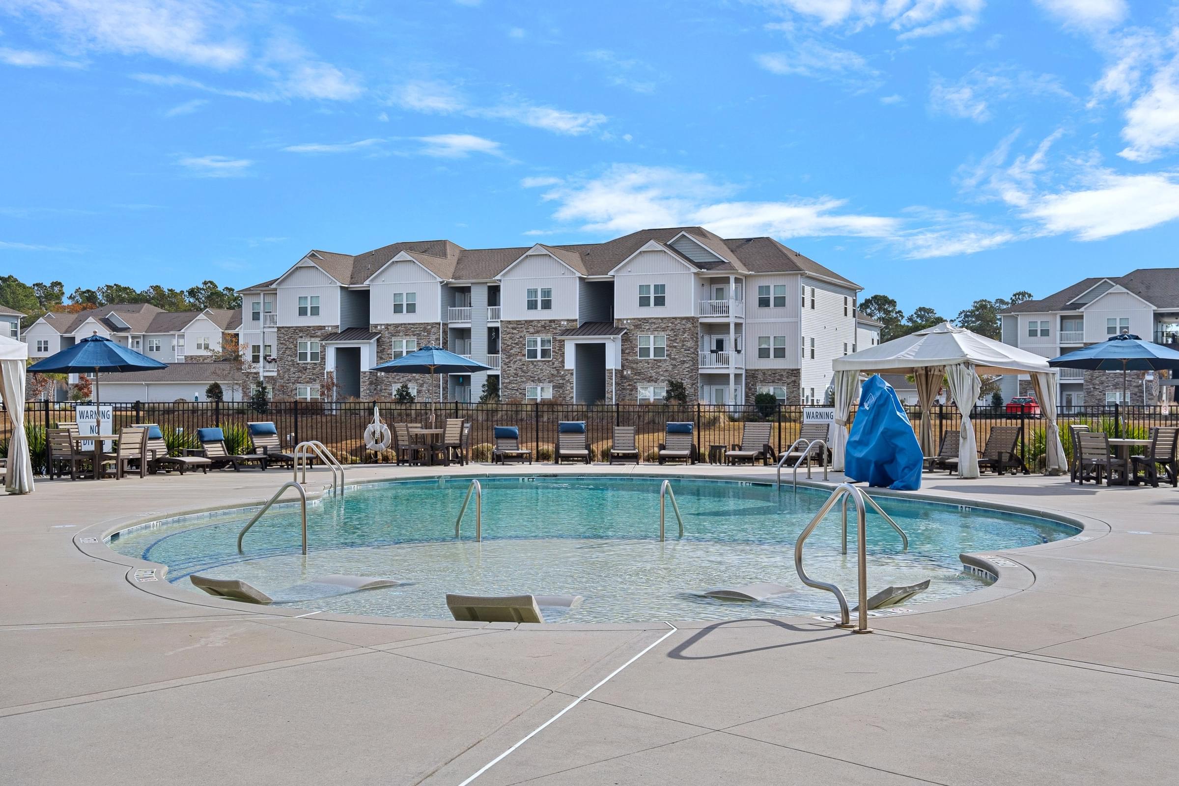 A swimming pool in front of apartment buildings.