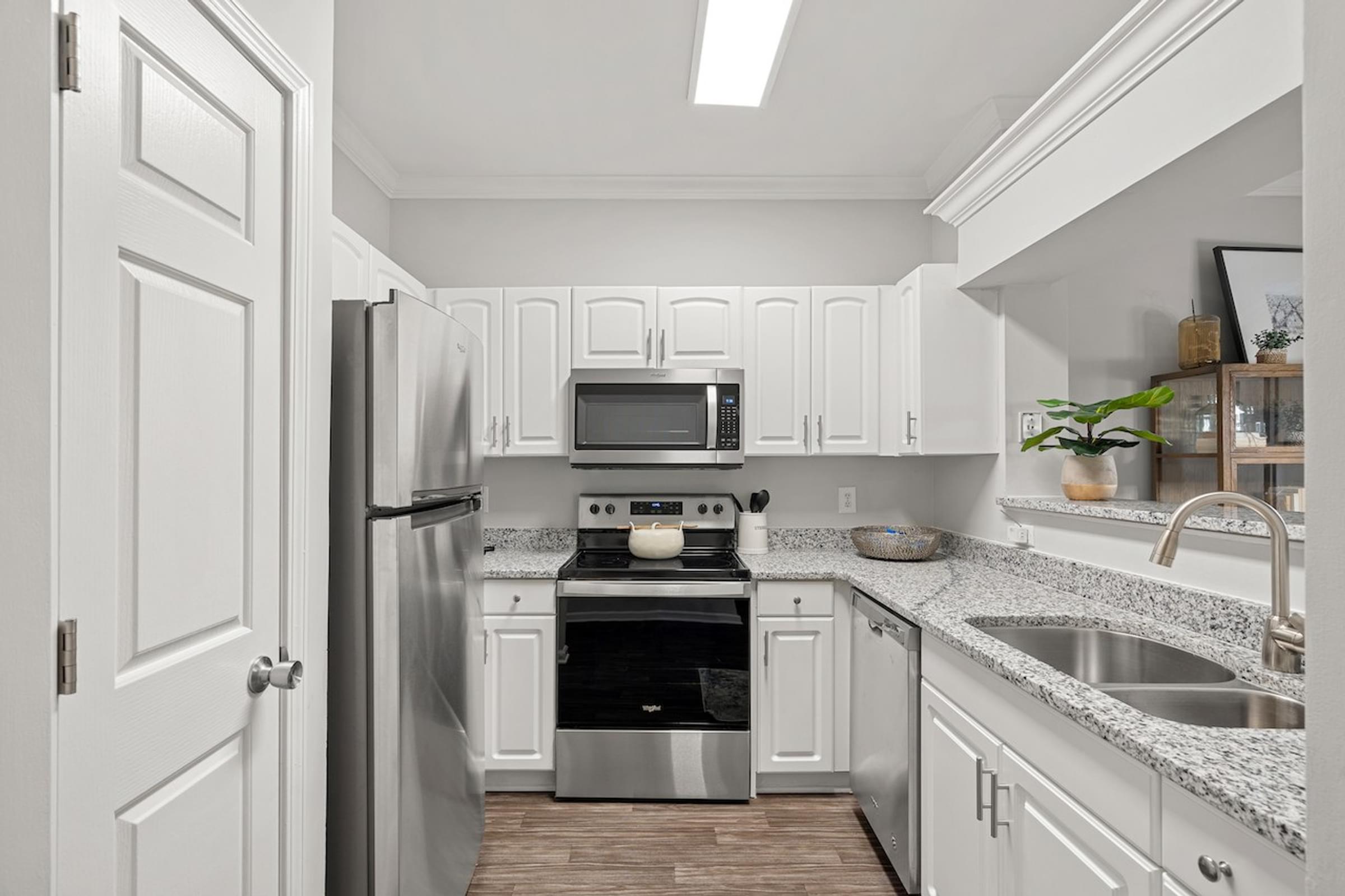 Spacious Kitchen with White Cabinets and Stainless Steel Appliances