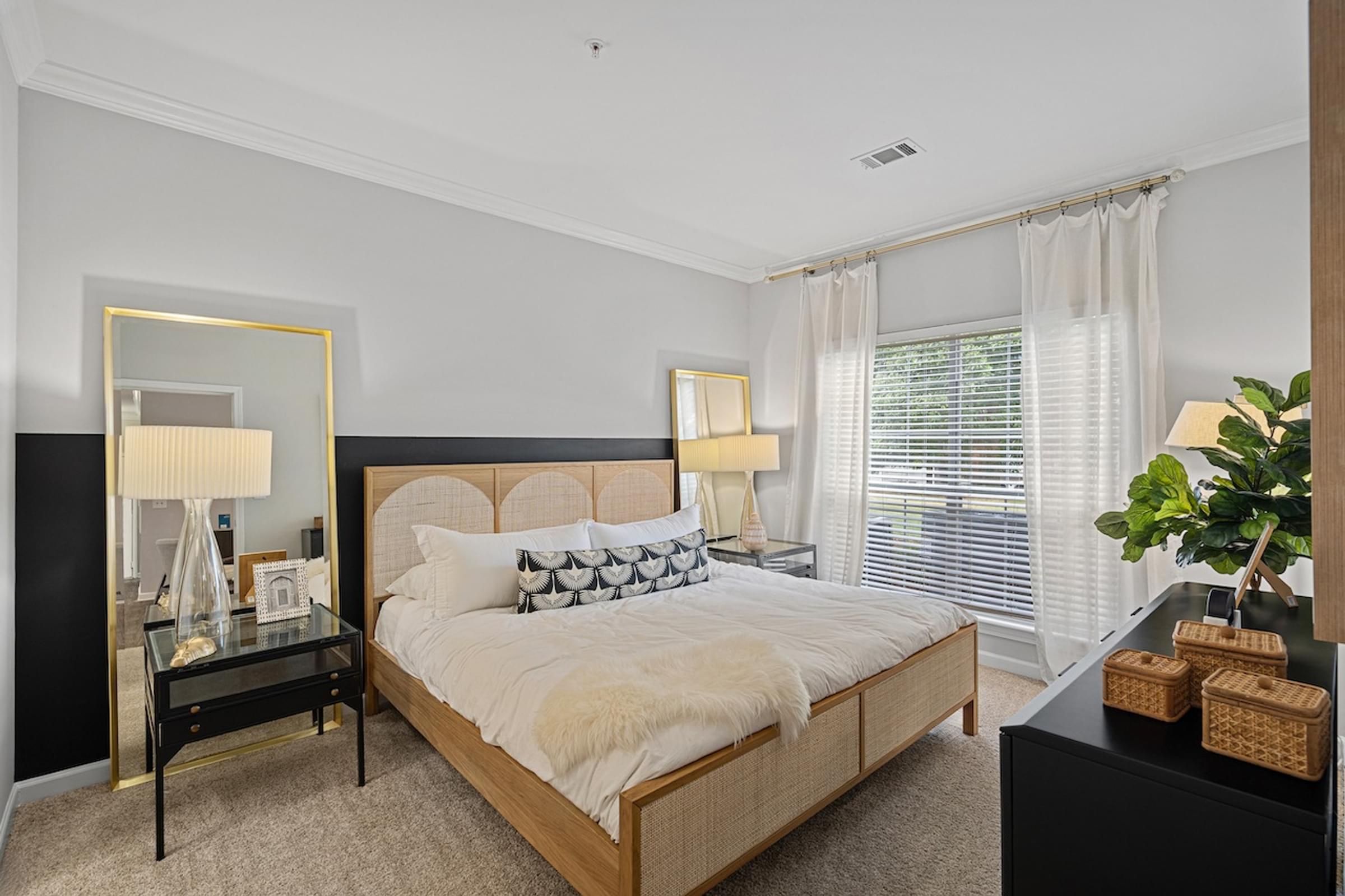 the master bedroom has a large bed and a large window