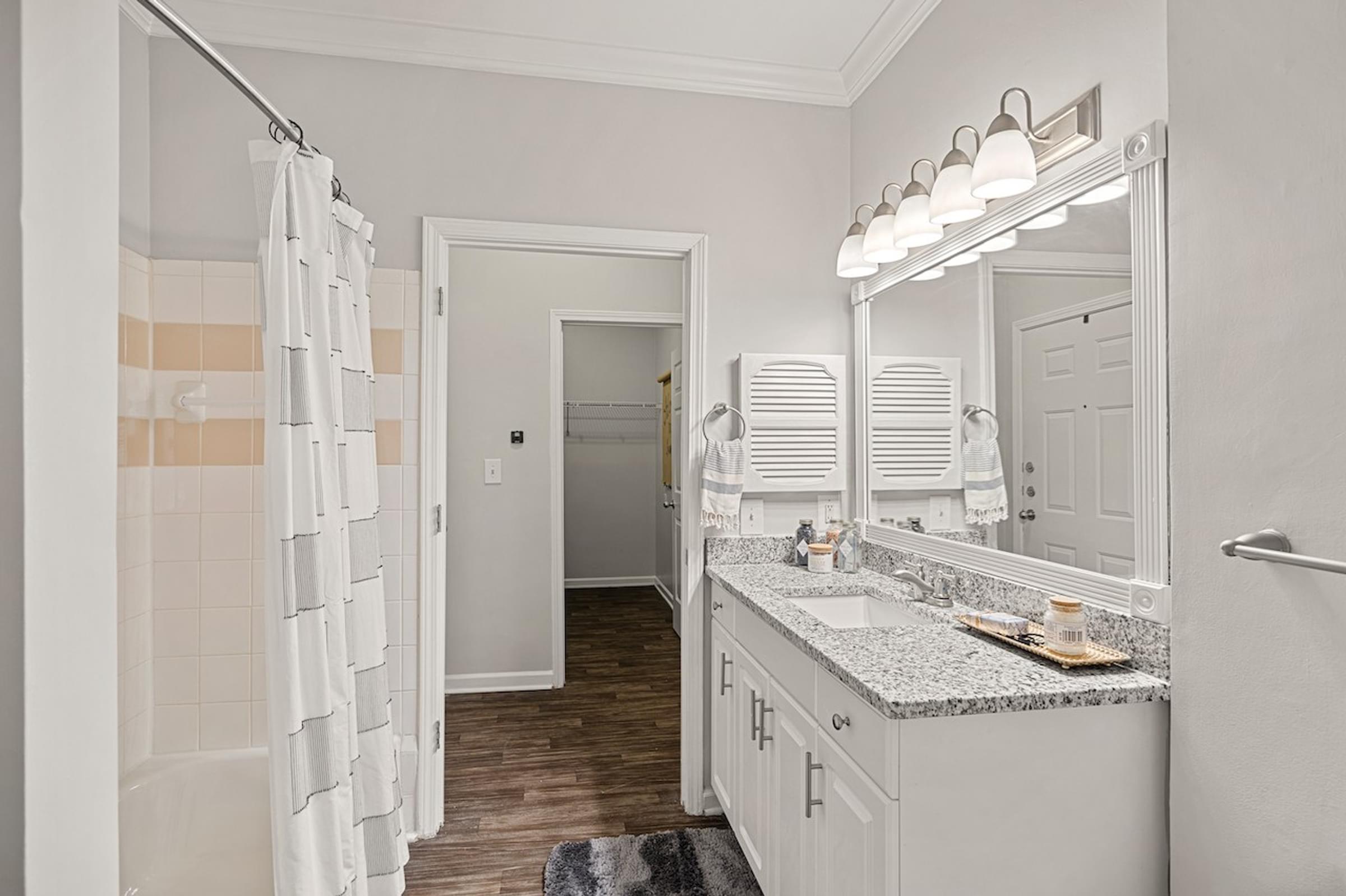 a bathroom with a shower and a sink and a mirror