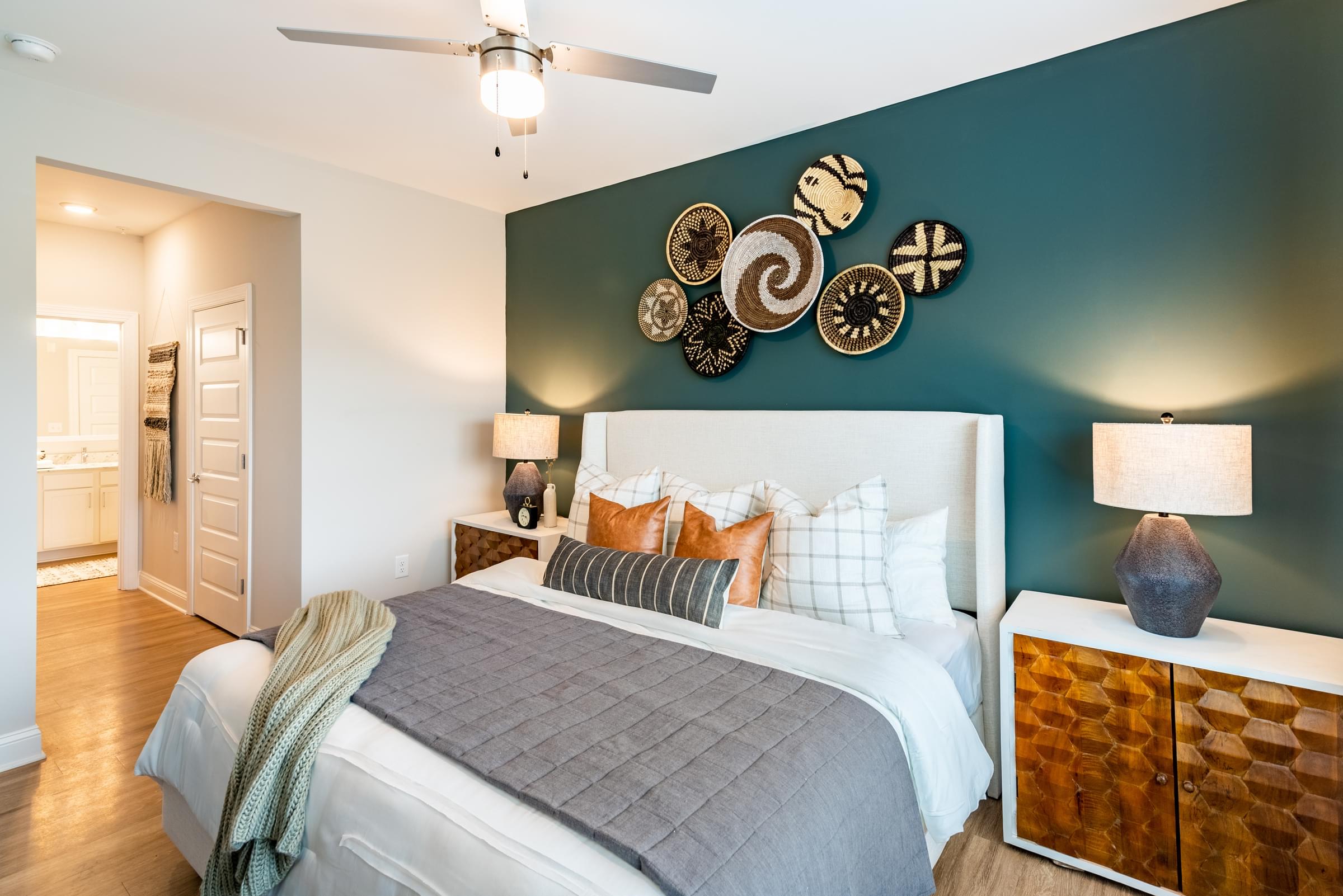 A bedroom with a bed, nightstand, and wall art