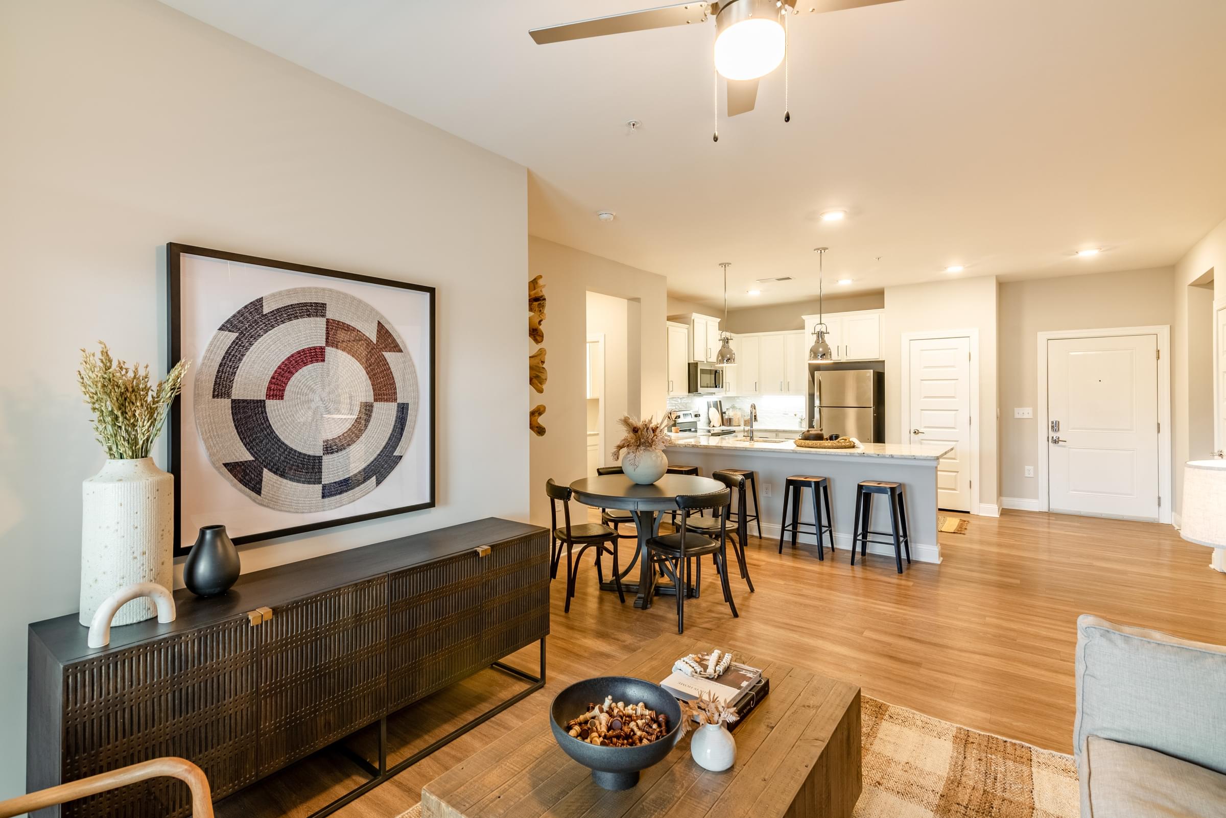 A modern living room with a large abstract artwork on the wall and a wooden coffee table in the center