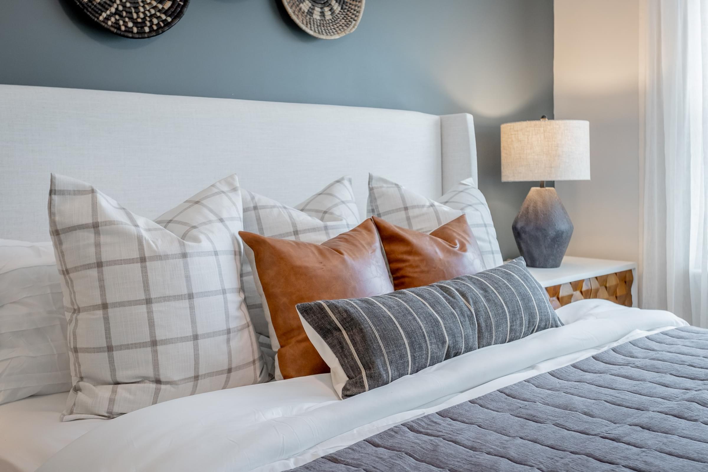 a bedroom with a large bed with pillows and a blue and white headboard