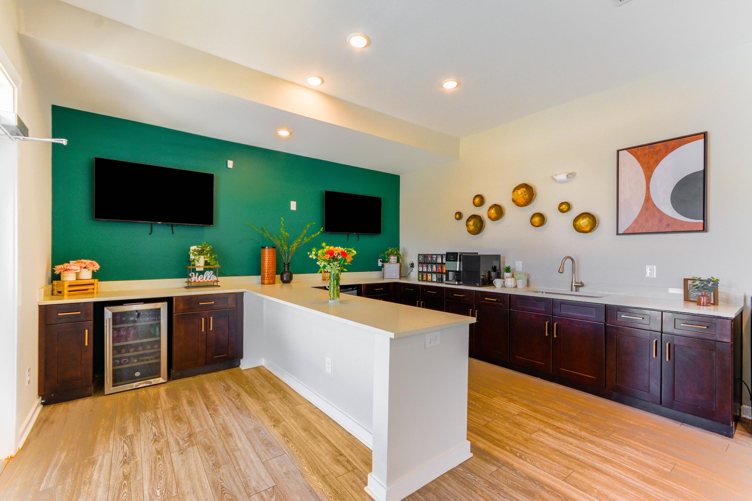 a large kitchen with a green wall and wooden floors