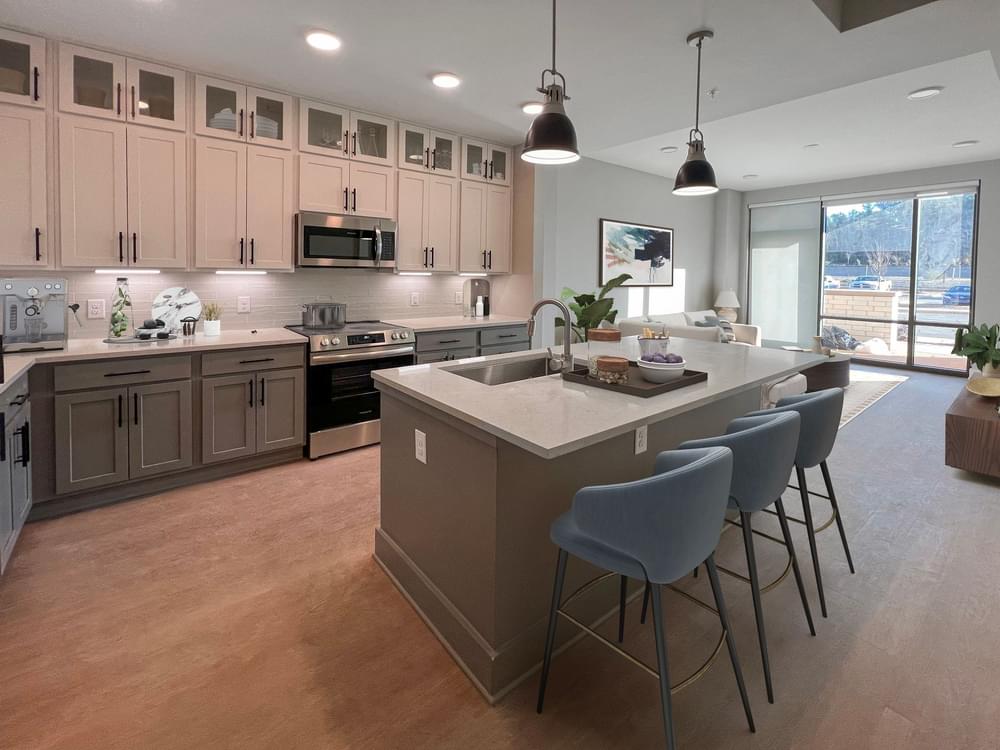 2 bedroom apartment kitchen and living area with pendant lighting, large kitchen island, and open concept layout