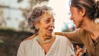 Joyful adult daughter greeting happy surprised senior mother