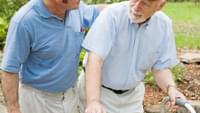 Senior man with walker and caregiver