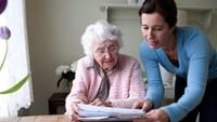 Senior woman looking at paperwork with caregiver