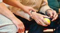 Carer Holding Elderly Mans Hand