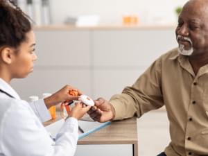 Doctor Giving an Elderly Man a Personal Alarm