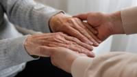 Hands Helping Up an Elderly Person