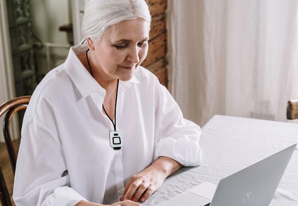Lady Sitting Inside Wearing SureSafe Fall Alert Wearable Personal Alarm