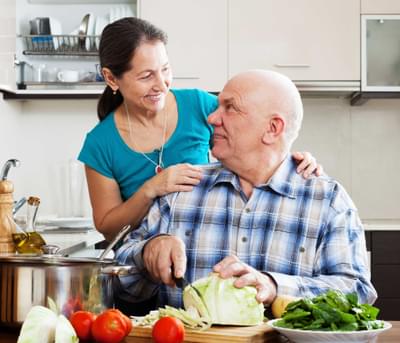 SureSafe Man Cutting Salad Woman with SureSafe 247 Pendant