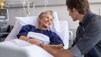 Man with Elderly Woman in Hospital
