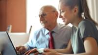 Woman and Elderly Man Using Laptop