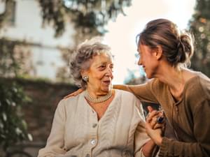 Daughter greeting senior mother in garden