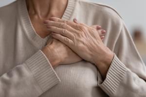 Senior woman with hands on chest