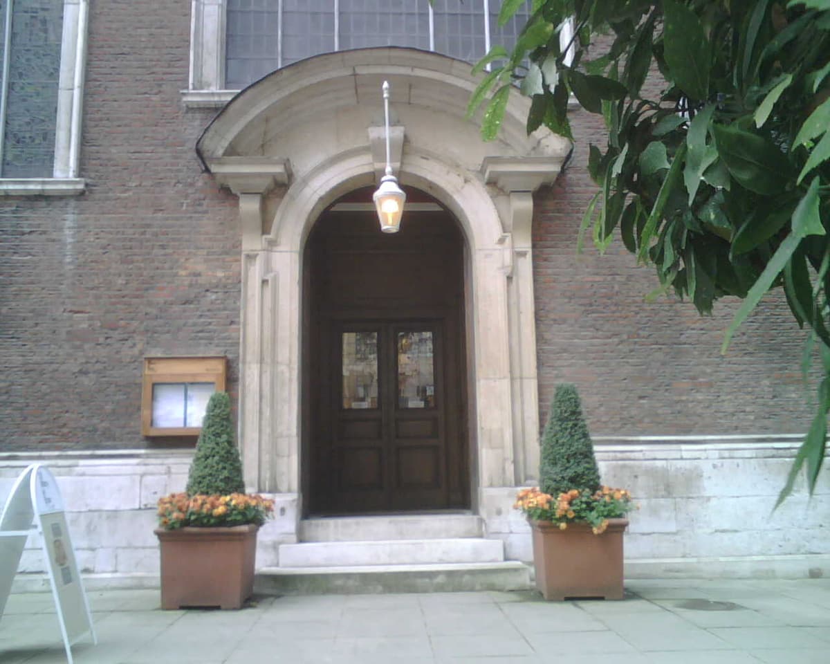 picture of church door with archway and plant pots on both sides