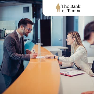 Bank professional (right) speaks with a customer (left) across a counter