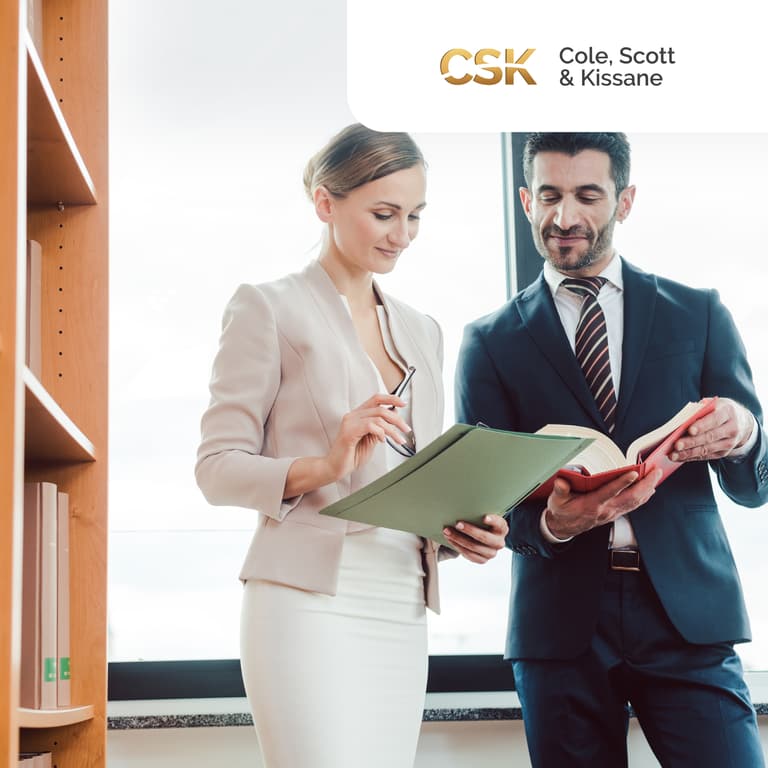 Two law professionals have a conversation, while holding a folder and a book