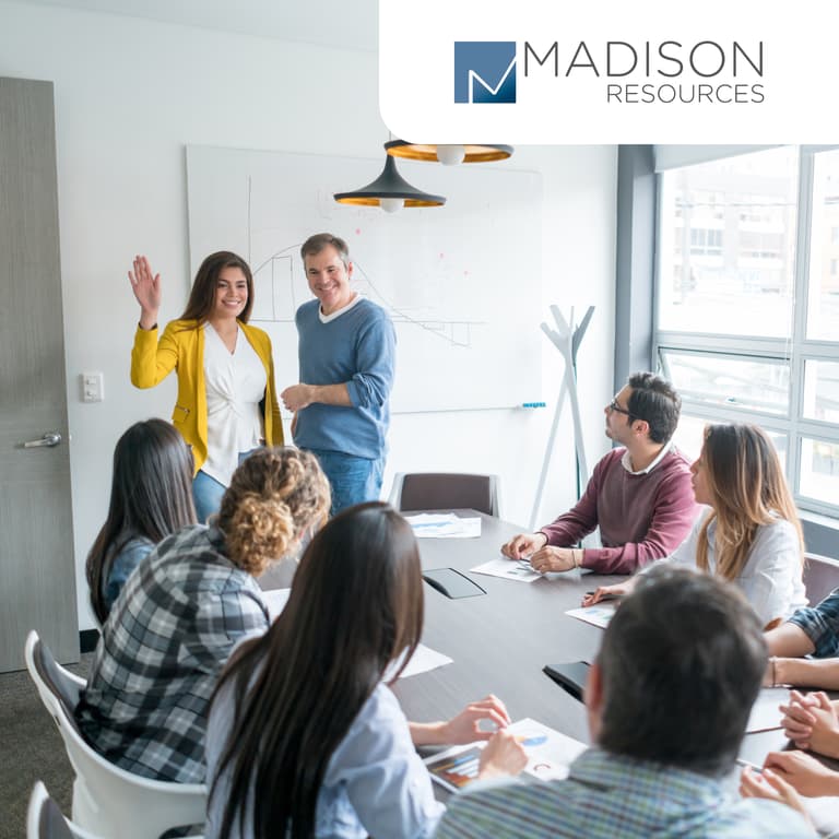 A group of people are gathered in an office-type setting
