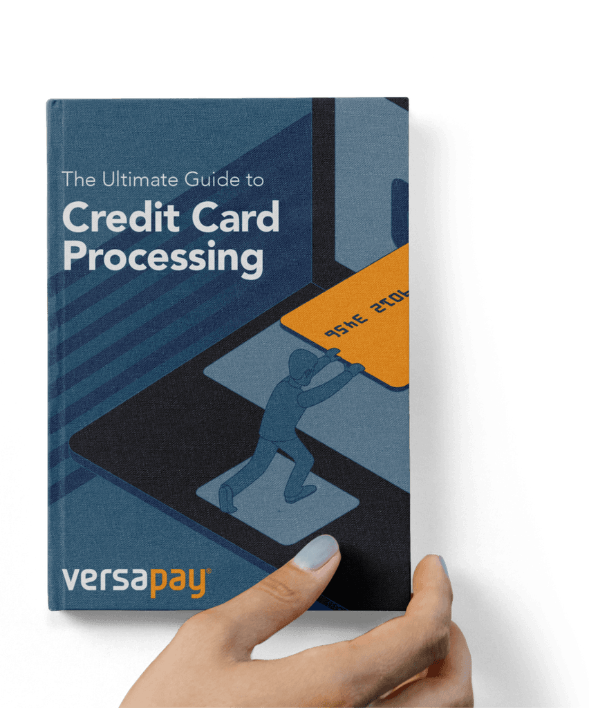 Hand holding the Ultimate Guide to Credit Card Processing eBook