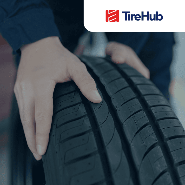 Person holding a tire with the TireHub logo in the upper right corner
