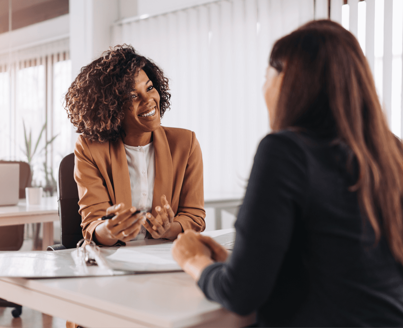 Two women smiling, having a conversation