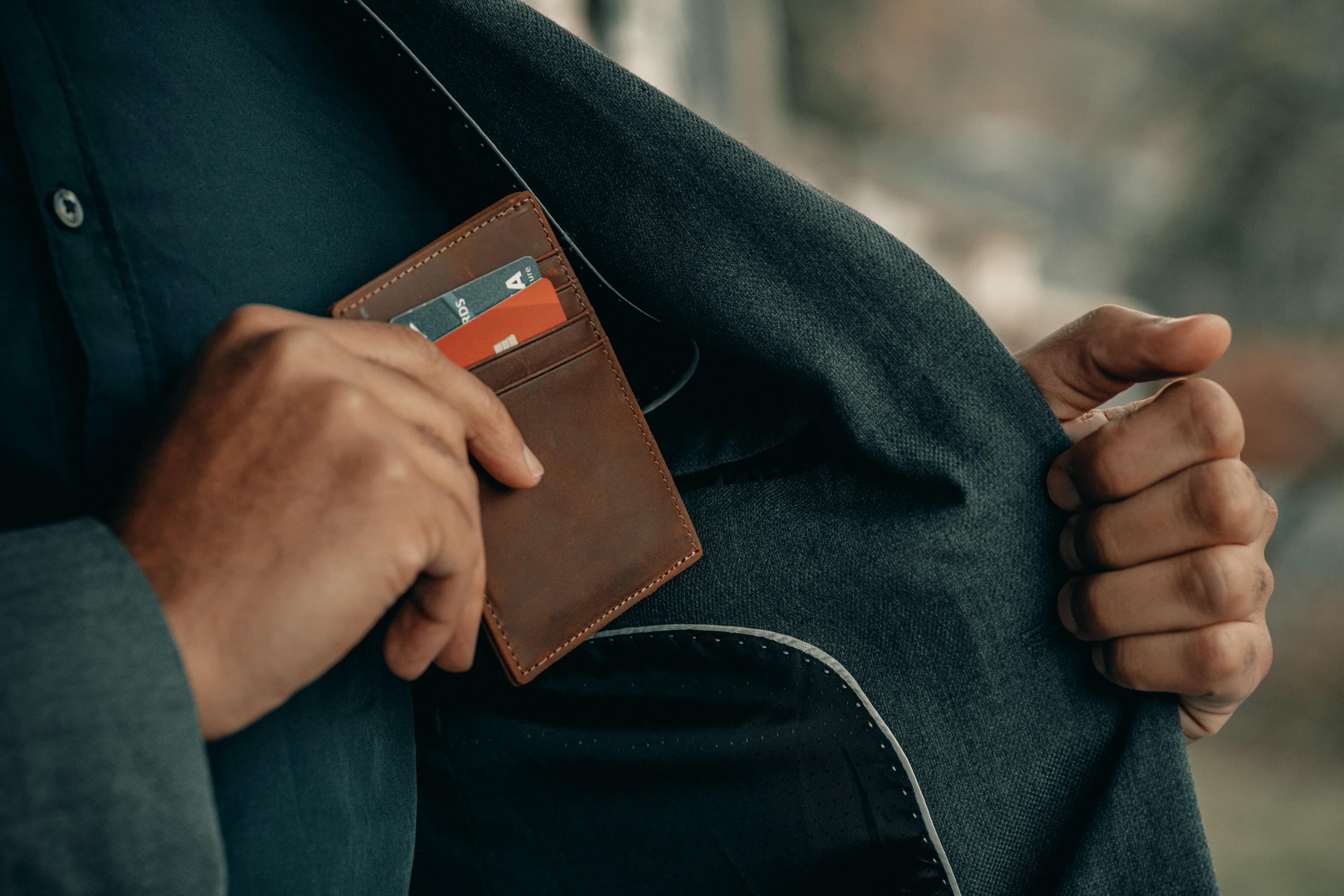 Person putting a wallet in their jacket pocket