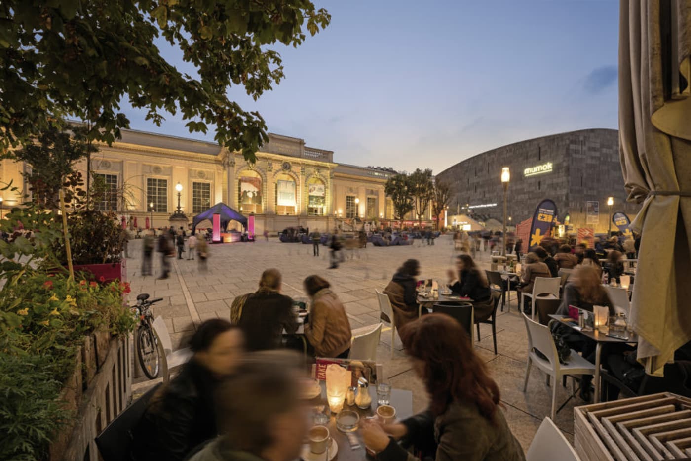 People at tables outside in evening
