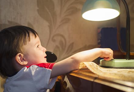 Anwendungsbeispiel Bild zeigt einen Jungen, der eine Tischlampe anschaltet
