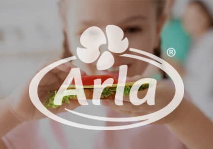 Thumbnail image of a girl enjoying a sandwich. The Arla logo is on top of the image.