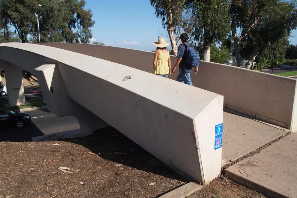 Concrete trail meets grade of concrete bridge with expansion joint in San Diego's Balboa Park at the Park Boulevard Overpass.